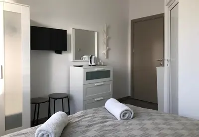 a small bathroom with a bed and a sink at Terra Guest House in Velingrad