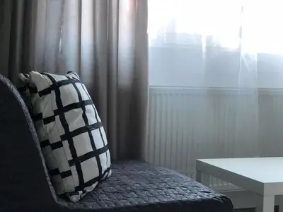 a pillow sitting on a chair next to a window at Terra Guest House in Velingrad