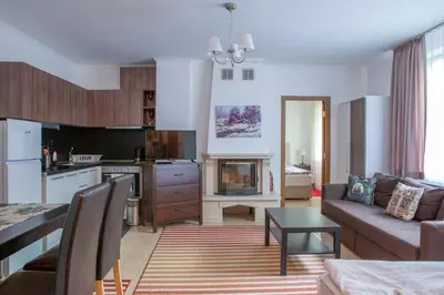 a kitchen and living room with a couch and a table at Apartments in Complex Grand Manastira in Pamporovo