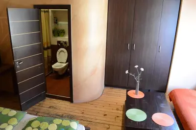 a room with a bathroom with a toilet and a table at Elegance on a Budget - Rooms for Rent in Sofia Center in Sofia