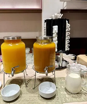 two jars of orange juice sitting on a table at Hotel Forum - Free Parking for cars in Sofia