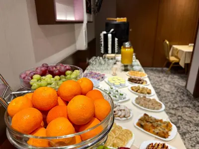 a table with plates of oranges and other food at Hotel Forum - Free Parking for cars in Sofia