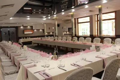 a room filled with tables and chairs with pink flowers at Hotel Forum - Free Parking for cars in Sofia