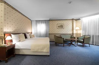 a hotel room with a bed and a table and chairs at Hotel Downtown in Sofia