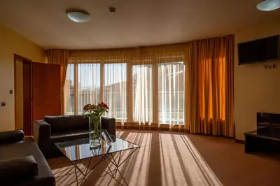 a living room with a couch and a glass table at Europe Hotel in Sofia