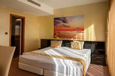 a bedroom with a bed with a painting on the wall at Europe Hotel in Sofia