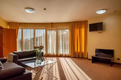 a living room with a couch and a tv at Europe Hotel in Sofia