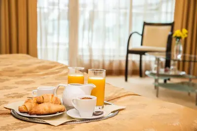 a tray of food and orange juice and croissants on a bed at Europe Hotel in Sofia