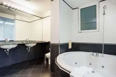 a bathroom with two sinks and a tub and a toilet at Europe Hotel in Sofia