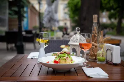 a wooden table with a plate of food and wine glasses at Grand Hotel Sofia in Sofia