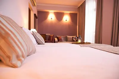 a hotel room with two beds and a couch at Hotel Lion Sofia in Sofia