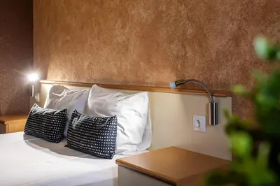 a bedroom with a bed with two pillows and a lamp at Hotel Brod - Free Parking in Sofia