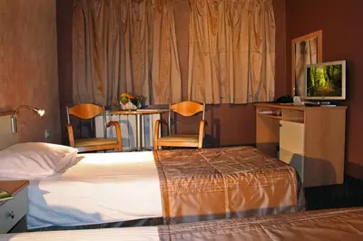 a hotel room with a bed and a table and chairs at Hotel Brod - Free Parking in Sofia