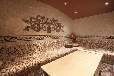 a room with a tiled wall with a wooden table at Royal Park Spa Bansko, private apartments within the complex in Bansko