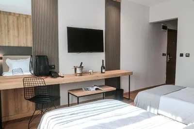 a hotel room with a bed and a desk with a television at Best Western Plus Lozenetz Hotel in Sofia