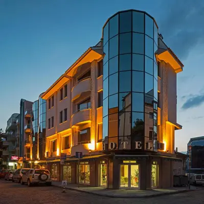 a tall glass building with cars parked in front of it at Hotel Dafi in Plovdiv