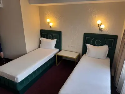 two beds in a small room with lights on the wall at Hotel Dafi in Plovdiv