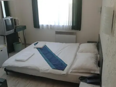 a bed in a room with a window and a television at Scotty's Boutique Hotel in Sofia