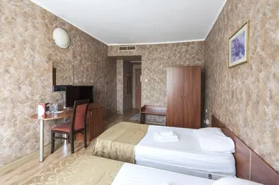 a hotel room with two beds and a desk at Hotel Akord - Free Parking & Metro Access in Sofia