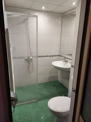 a bathroom with a shower and a toilet and a sink at Hotel Akord - Free Parking & Metro Access in Sofia