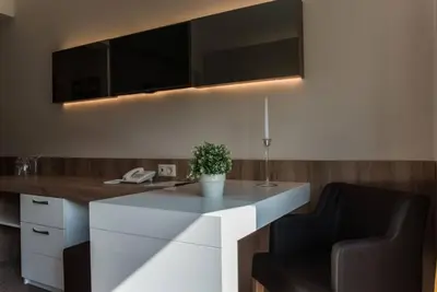 a kitchen with a white counter and two chairs at Jasmin Hotel in Sofia