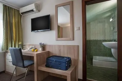 a hotel room with a suitcase in a bathroom at Jasmin Hotel in Sofia