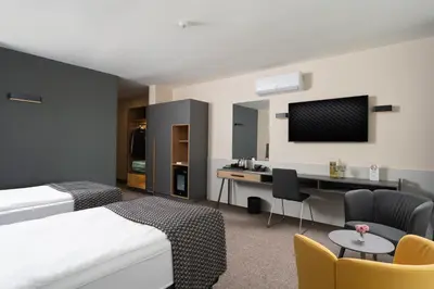 a hotel room with a bed and a desk and a tv at Jasmin Hotel in Sofia