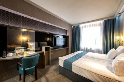 a hotel room with a bed and a desk at Spa Hotel Ezeretz Blagoevgrad in Blagoevgrad