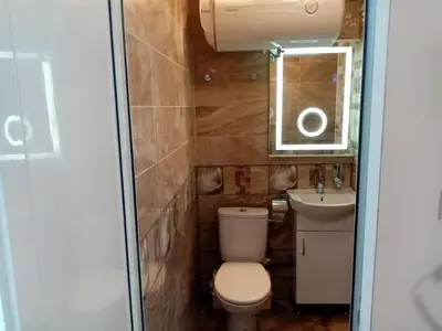 a bathroom with a toilet and a sink and a mirror at Benita Inn apartments in Sofia