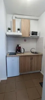 a small kitchen with a sink and a microwave at Benita Inn apartments in Sofia
