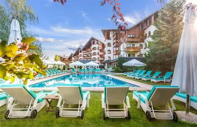 a hotel with a pool and chairs and a hotel at Kempinski Hotel Grand Arena Bansko in Bansko
