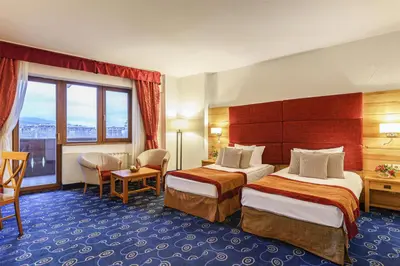 a hotel room with two beds and a window at Kempinski Hotel Grand Arena Bansko in Bansko