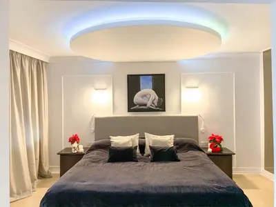a bedroom with a large bed and a large light fixture at Atlantic Hotel - Free Parking in Sofia