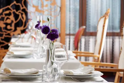 a long table with plates and vases with purple flowers at Atlantic Hotel - Free Parking in Sofia