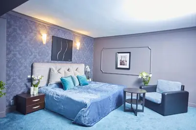 a blue bedroom with a bed and a chair at Atlantic Hotel - Free Parking in Sofia