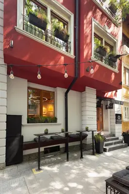 a red building with benches in front of it at Oborishte 63,The Art Boutique Hotel by Sandglass in Sofia
