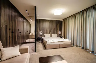 a bedroom with a bed and a couch in a room at Perun Hotel Sandanski in Sandanski