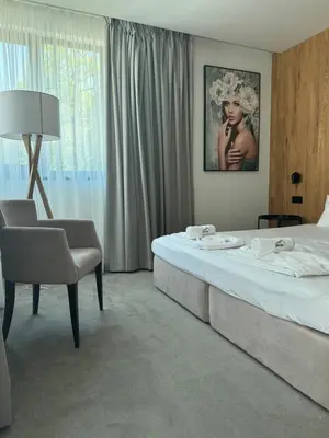 a hotel room with a bed and a chair at Perun Hotel Sandanski in Sandanski