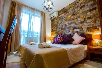 a bedroom with a large bed with towels on it at St. John Hill Bansko in Bansko