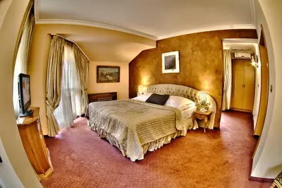 a bedroom with a large bed in a room at Meg-Lozenetz Hotel in Sofia