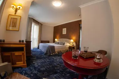 a hotel room with a bed and a red table at Meg-Lozenetz Hotel in Sofia