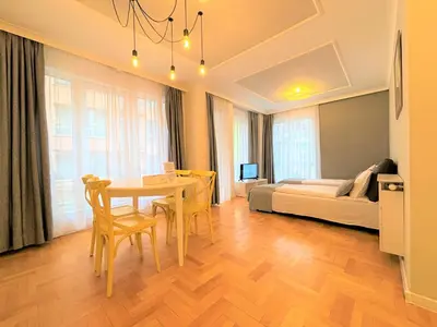 a living room with a table and chairs and a bed at Dunav Apartment House in Sofia