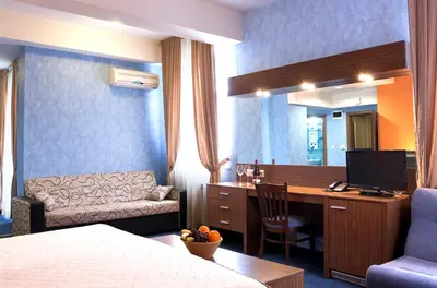 a hotel room with a bed and a desk with a computer at DITER Family Hotel in Sofia