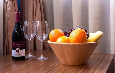 a bowl of fruit and two wine glasses on a table at DITER Family Hotel in Sofia