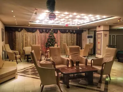 a christmas tree in a room with chairs and a table at Troyan Plaza Hotel in Troyan