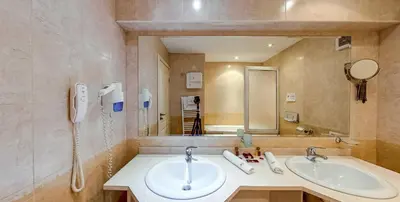 a bathroom with two sinks and a large mirror at Troyan Plaza Hotel in Troyan