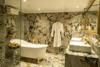 a bathroom with a bath tub and a sink at Spa Hotel Rich in Velingrad