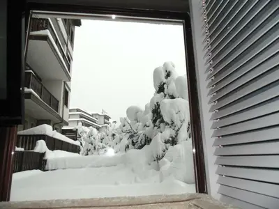 a window covered in snow outside a building at Fortuna Luxury Apartment in Bansko