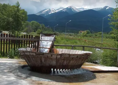 a wooden boat sitting on top of a fountain at Fortuna Luxury Apartment in Bansko