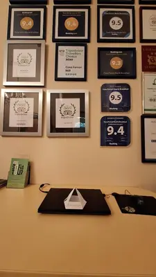 a desk with certificates and pictures on a wall at Casa Ferrari Bed & Breakfast in Sofia